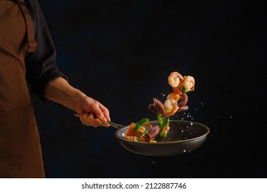 Cocina de marisco - camarones, pulpo con verduras en una sartén sobre fondo negro por un chef profesional. Alimentos congelados a bordo. Comida marina. Vegetariano, alimentos dietéticos. Cartel.