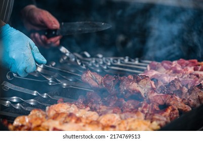 Cooking shish kebab on skewers. Meat, vegetables and bread rolls baked on coals.A male chef roasts juicy beef, chicken, pork.The concept of street food. Grilled meat on the grill.Meat on the barbecue. - Powered by Shutterstock