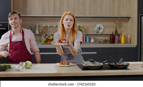 Cooking Show Hosts Chefs, Male And Female, Showing Cooked Dish Into Camera. Morning TV Cooking Programme