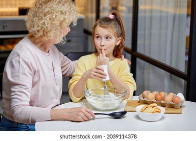 Cooking With Soul. Adorable Little Child Help Senior Grandma At Kitchen Mix Dough For Cookies Pancakes. Smiling Older Granny Teach Small Grandkid To Bake Homemade Cake Pastry Share Family Recipe