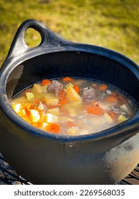 Cooking soup on wood fired grill - Shutterstock ID 2269568035