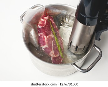  Cooking sous vide. Raw meat with  rosemary in airtight vacuum sealed bag 
in pot.

