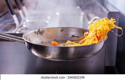 Cooking Spaghetti Concept. Pasta In The Pan. Cooking Fresco Pasta.  Italian Cuisine, Tomato Sauce For Pasta, Healthy Food Making, Detailed View Steam In The Kitchen. Flipping Pasta In The Air