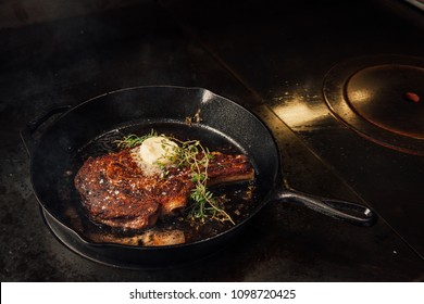 Cooking steak in a cast iron pan in a fine dining restaurant.