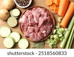 Cooking stew. Uncooked meat and vegetables on wooden table, flat lay