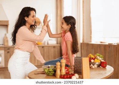 Cooking Success. Joyful Mom And Little Daughter Preparing Dinner And Giving High Five, Having Fun In Modern Kitchen At Home. Woman And Her Kid Girl Preparing Tasty Healthy Food Together - Powered by Shutterstock