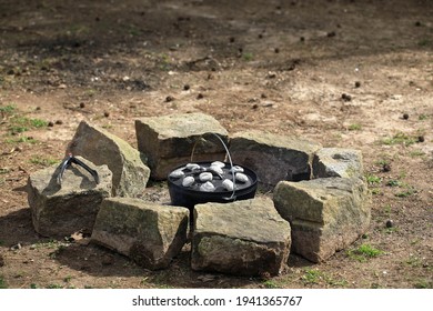 Cooking Supper In A Dutch Oven With Coals On Lid In Fire Ring.