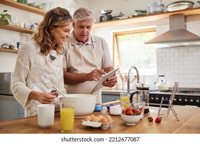 Cooking, tablet and old couple learning baking skills online at home kitchen in a lovely and romantic marriage. Recipe, eggs and elderly woman prepares strawberry cake, food and cookies with partner - Powered by Shutterstock