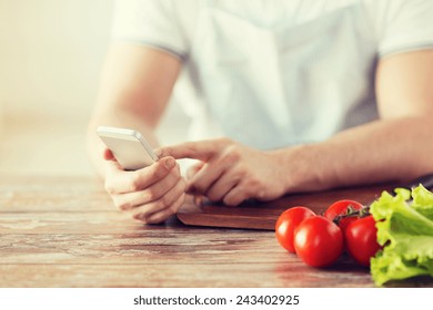 cooking, technology and home concept - closeup of man pointing finger to smartphone - Powered by Shutterstock