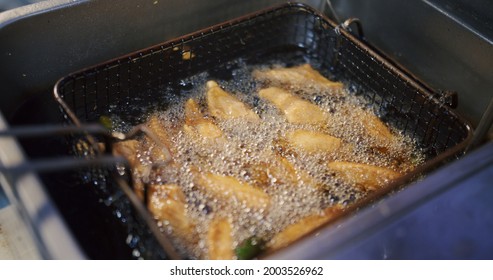 Cooking Thai Style Food Deep Fried Crispy Chicken Wings In Boiling Hot Oil Basket At The Kitchen