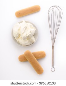Cooking tiramisu. Mascarpone and Savoiardi with a whisk for whipping, isolated on white background.