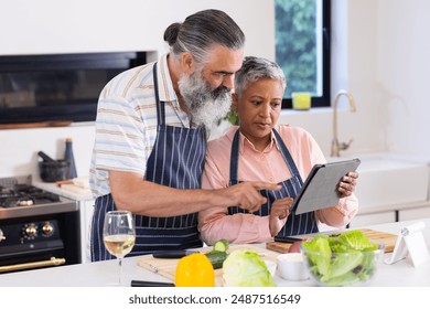 Cooking together, senior couple using tablet for recipe in modern kitchen. seniors, food preparation, technology, lifestyle, home, meal - Powered by Shutterstock