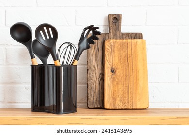 Cooking tools with wooden cutting boards, oil and shaker at white modern kitchen interior. - Powered by Shutterstock