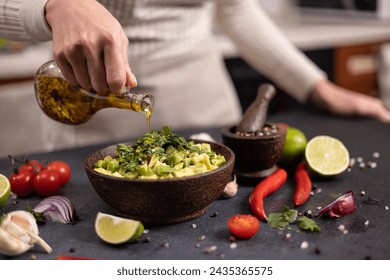 Cooking traditional salsa - woman pours olive oil into bowl with sliced chopped ingredients - Powered by Shutterstock