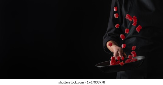 Cooking tuna, red fish, frying in a pan, freezing in motion, horizontal photo on a black background - Powered by Shutterstock