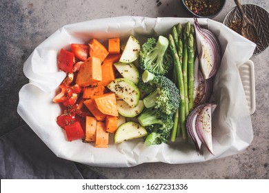 Cooking Vegetables For Baking In The Oven Dish. Raw Pepper, Sweet Potato, Asparagus, Broccoli And Onions With Oil And Spices.