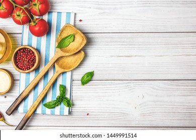 Cooking Wooden Utensils, Olive Oil, Spices And Light Blue, White Napkin On White Wooden Background. Food Cooking Concept. Top View. Copy Space