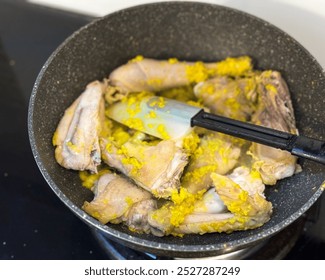 Cooking yellow chicken curry or kari ayam on the stove. Known in Thai as kaeng kari, dish made from cumin, coriander, turmeric, fenugreek, garlic, bay leaf, lemongrass, cayenne pepper, ginger. - Powered by Shutterstock