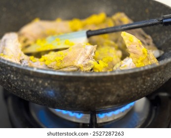 Cooking yellow chicken curry or kari ayam on the stove. Known in Thai as kaeng kari, dish made from cumin, coriander, turmeric, fenugreek, garlic, bay leaf, lemongrass, cayenne pepper, ginger. - Powered by Shutterstock