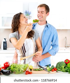 Cooking.Happy Couple Cooking Together - Man And Woman In Their Kitchen At Home Preparing Vegetable Salad.Diet.Dieting. Healthy Food