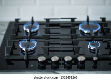Cooktop with burning gas ring. Gas cooker with blue flames - Shutterstock ID 1332451268