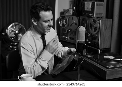 A Cool 1950's 60's Retro Radio DJ plays music while holding record and cigarette  - Shutterstock ID 2143714261