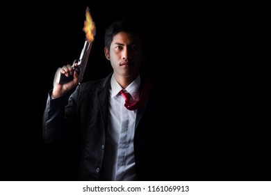 Cool aggressive man in shirt and jacket pointing a gun ,Black background and copy space