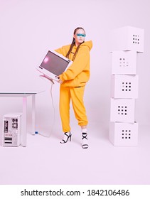 Cool Asian Female Office Worker With Obsolete Computer Monitor And Boxes. Colored Neon Light