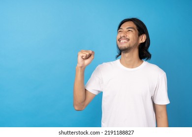 Cool Asian Man Excited And Surprised On Blue Background. A Man Saw A Sale On An Online Shopping Website Or See The Results Of The Football Team Cheering Competition.