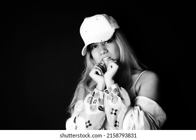 Cool Attitude Woman Biting Chain While Standing Over Black Background