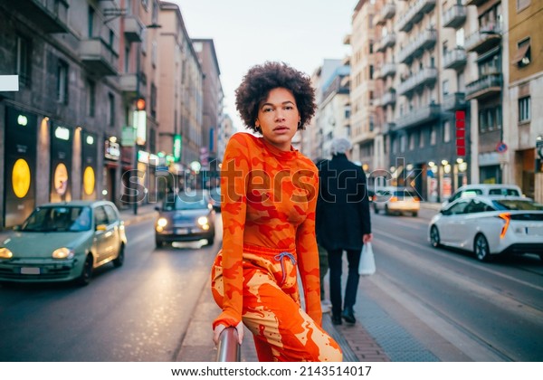 Cool attitude young black woman posing outdoor\
looking camera serious