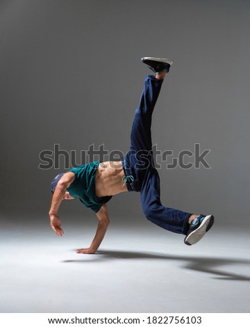 Cool boy dancing in studio isolated on gray background with copy space. Breakdancing school poster