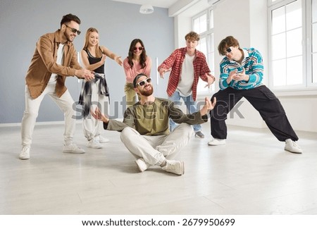 Cool dancer man, group of dancing people actively dancing indoors, moving and posing in studio space, dance class, rehearsal in dynamic pose, enjoying practicing or performing, having fun together