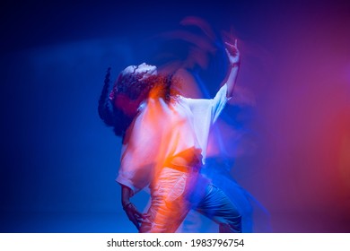 Cool dancing young mixed race girl in colorful neon studio light. Long exposure. Contemporary hip hop dance, rap rhythm - Shutterstock ID 1983796754