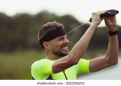 Cool Down, Wash Face. Young Male Triathlete, Runner Resting Outdoors On Open Road. Concept Of Sport, Lifestyle, Motion And Action. Copyspace For Ad.