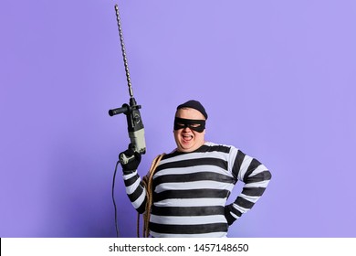 Cool Excited Fat Man With Hand On His Hip Holding A Drill Like A Gun And Looking At The Camera. Close Up Portrait.