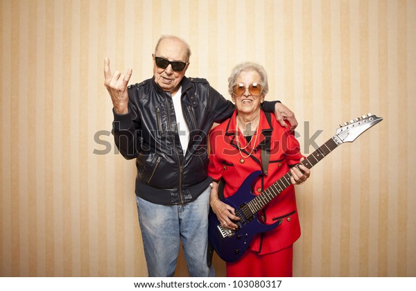エレキギターを持つクールファッションの老夫婦 の写真素材 今すぐ編集