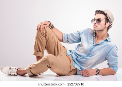Cool Fashion Man Lying On The Floor, Holding One Knee Up, Looking Away From The Camera.