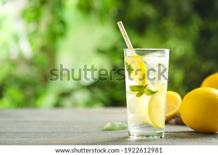 Cool freshly made lemonade and fruits on grey wooden table. Space for text