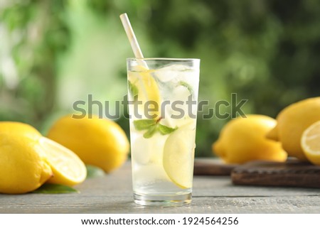 Cool freshly made lemonade and fruits on grey wooden table