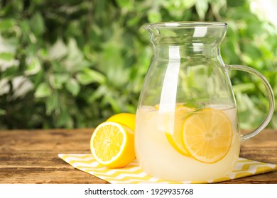 Cool Freshly Made Lemonade In Glass Pitcher On Wooden Table. Space For Text