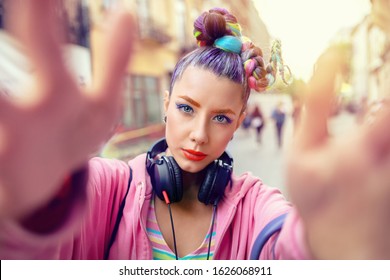 Cool funky young rebel girl with headphones and crazy hair enjoy power of music taking selfie on street – hipster woman with trendy avant-garde look having fun - Music fan concept with carefree teen - Shutterstock ID 1626068911