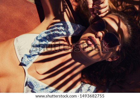 Similar – Two women with sunglasses smiling lying in blanket