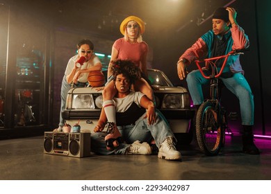 A cool group of retro stylish friends are hanging out outdoors with their bike, car, boombox and roller skates. - Shutterstock ID 2293402987