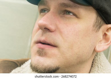 Cool Guy In Aviator Jacket And Newsie Cap Relaxes Against A Glass Wall