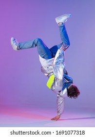 Cool Guy Dancing Contemporary Dance In Studio. Neon Light Background. Acrobatic Bboy Dancer. Break Dance Lessons.