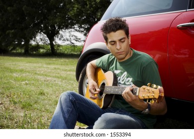 Cool Guy Playing Guitar Besides His Car