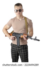 Cool Handsome Young Man In A Beige T-shirt And Plaid Pants With Sunglasses Holding An Assault Rifle Isolated On White Background