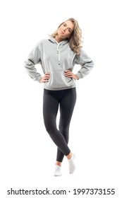 Cool Happy Young Woman In Gray Sweatshirt And Leggings Posing With Hands On Hips. Full Body Length Isolated On White Background.