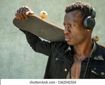 Cool Isolated Portrait Of Young Attractive And Confident Hipster Black African American Man Walking On Street Holding Skate Board Looking A Badass Guy In Urban Style Concept